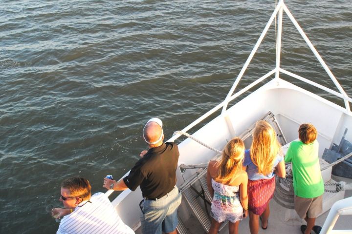 a group of people standing next to a body of water